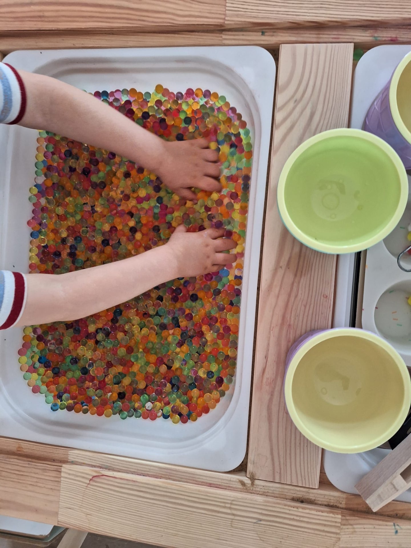 Kolorowe kulki wodne w tacy sensorycznej
